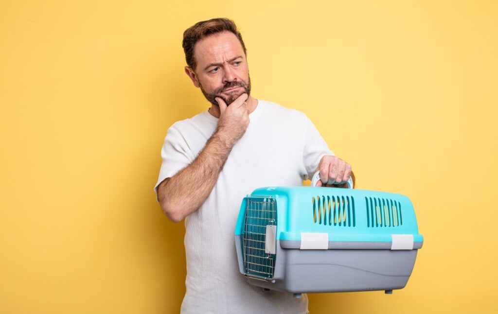 A man is holding a cat carrier